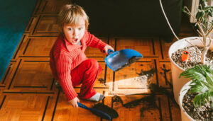 Child tidying messy home. Paul Claireaux